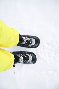 Low section of person snowshoeing on snow