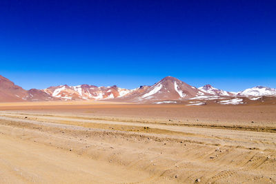 Scenic view of desert against clear blue sky