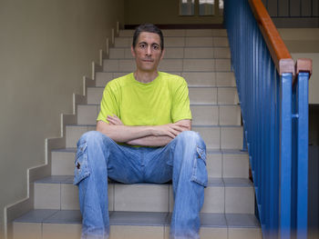 Portrait of man sitting on staircase