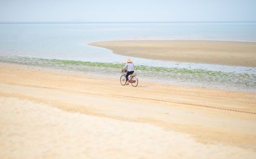 Man cycling on beach