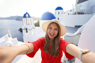 Excited traveler girl taking selfie photo in santorini on sunset