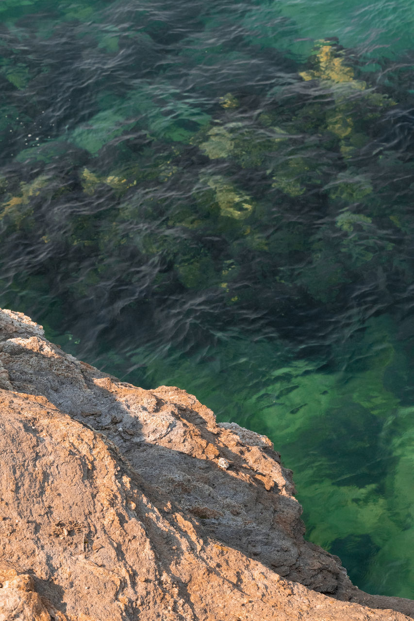 HIGH ANGLE VIEW OF ROCK FORMATION AMIDST WATER