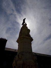 Low angle view of monument against cloudy sky