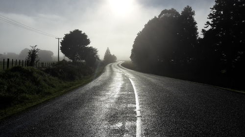 Road amidst trees against sky