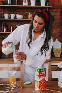 Young woman holding drink in restaurant