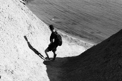 High angle view of man standing on mountain by sea