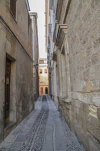 Empty alley amidst buildings in city