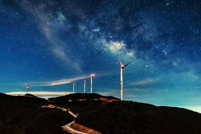 Windmills on mountains against star field