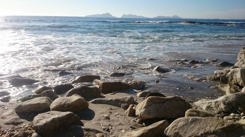 Rocks on beach against sky