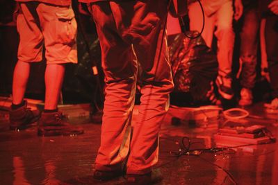 Low section of people standing on wet floor 