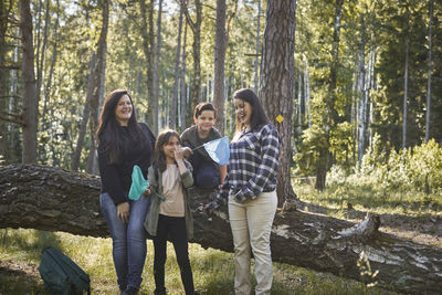 Full length of a smiling young woman in forest