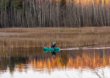 Man surfing on lake in forest