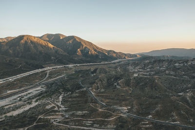 Aerial view over california country site desert mountains with highway and car traffic