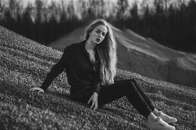 Full length portrait of woman sitting on grass