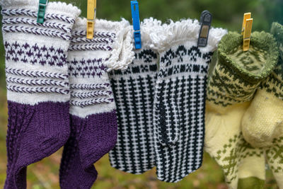 Photography with knitted gloves, gloves hanging on a rope, handicraft concept, knitting as a hobby