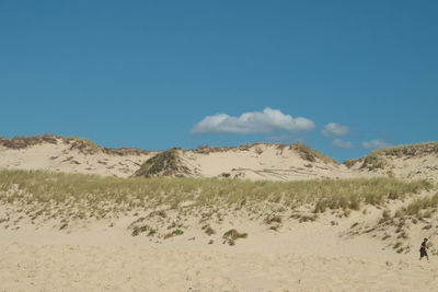 Scenic view of desert against blue sky