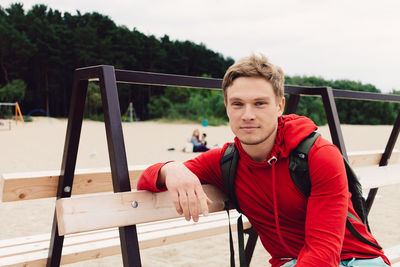 Portrait of young man sitting on bench