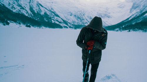 Rear view of person standing on snow covered mountain