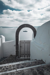 Built structure by sea against sky