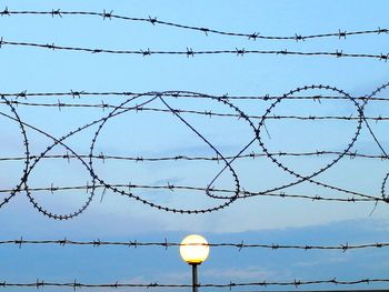 Illuminated lamp post against barbed wire