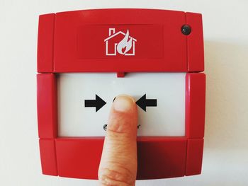 Close-up of hand sign on red wall