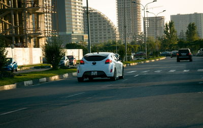 Cars on road by buildings in city