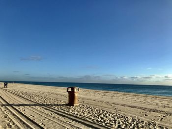 Scenic view of beach against blue sky