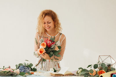 Beautiful young woman with flower vase on table