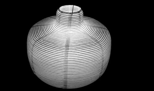 Low angle view of illuminated lamp against black background