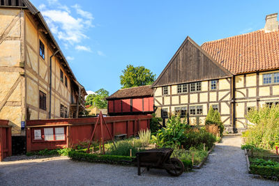 Houses by building against sky