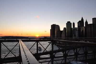 View of bridge and buildings against sky during sunset