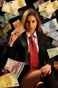 Young woman holding camera while sitting in store