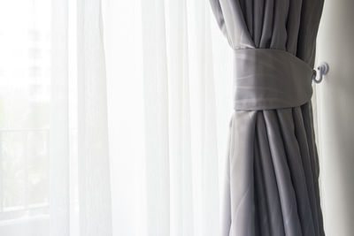 Midsection of man standing by window at home