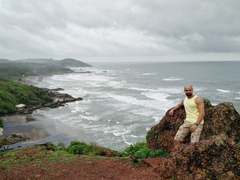 Man standing at beach against sea and sky