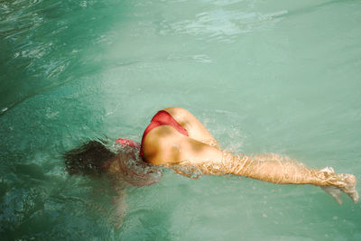 Low section of woman swimming in water
