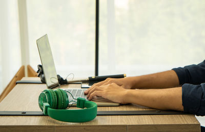 Midsection of man working on laptop on table
