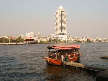 Ship in river against buildings in city