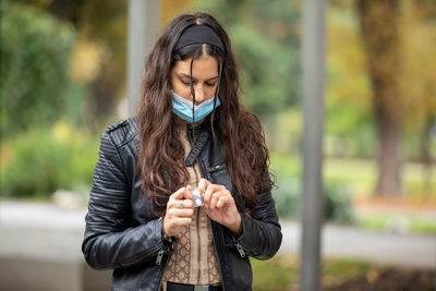 A beautiful girl holding pills to reduce sharp ache or virus symptoms while walking at the street