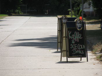 Information sign on sidewalk by street in city