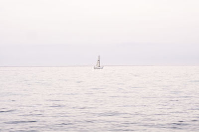 Sailboat sailing on sea against clear sky