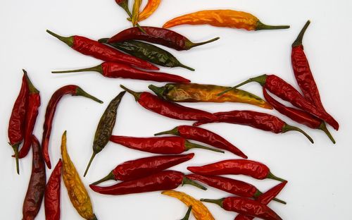 High angle view of red chili pepper against white background