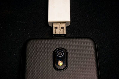 High angle view of mobile phone with usb stick on table