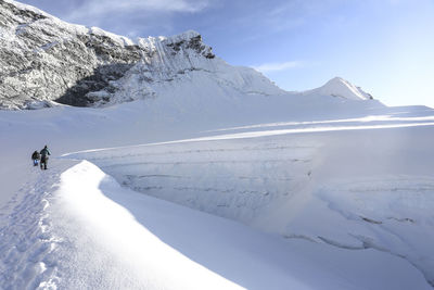 Hikers on snow covered landscape