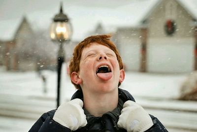 Close-up of a boy sticking out tongue in winter