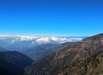 Scenic view of mountains against blue sky