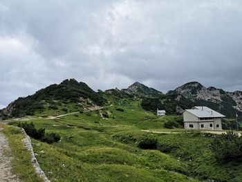 Scenic view of houses by mountains against sky