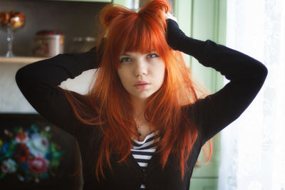 Portrait of beautiful young woman standing at home