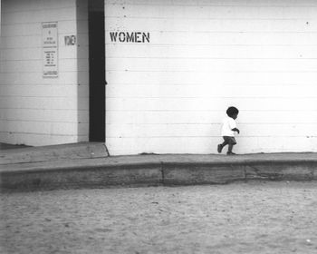 Boy standing against built structure