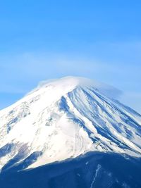 Scenic view of snowcapped mountains against blue sky