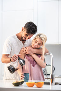 Couple holding ice cream at home